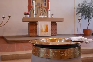 Lutherisches Taufbecken mit Inschrift in einer Kirche.